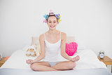 Peaceful natural brown haired woman in hair curlers practicing yoga