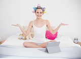 Relaxed natural brown haired woman in hair curlers moving her arms