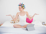 Calm natural brown haired woman in hair curlers moving her arms