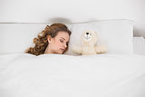 Attractive brunette sleeping next to teddy bear