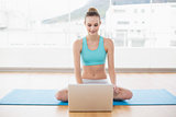 Sporty smiling woman using laptop