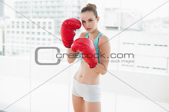 Sporty serious woman wearing boxing gloves