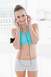 Sporty smiling woman listening to music