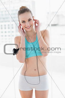 Sporty smiling woman listening to music