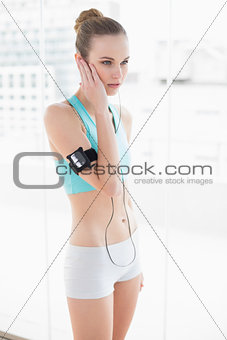 Sporty stern woman listening to music