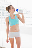 Sporty young woman holding water bottle