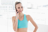 Sporty happy woman phoning with smartphone