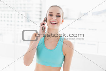 Sporty laughing woman phoning with smartphone
