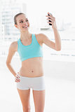 Sporty attractive woman smiling at smartphone