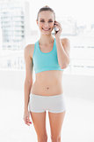 Sporty smiling woman using smartphone