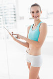 Sporty smiling woman using a tablet