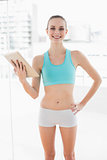 Sporty smiling woman holding a tablet