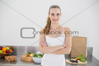 Pretty smiling woman standing cross-armed