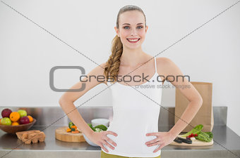 Pretty smiling woman standing hands on hips