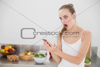 Shocked young woman reading a texting