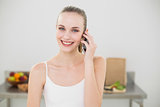 Happy young woman talking on smartphone smiling at camera