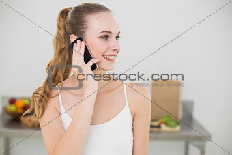 Smiling young woman talking on smartphone