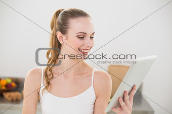 Cheerful young woman holding her digital tablet