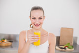 Happy young woman holding glass of orange juice