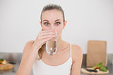 Happy young woman drinking glass of water