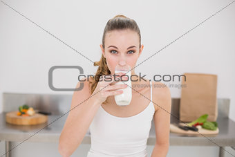 Serious young woman drinking glass of milk