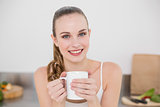 Cheerful young woman holding mug