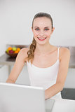 Cheerful young woman using her laptop