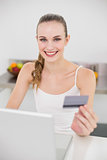 Happy young woman using her laptop for online shopping