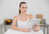 Serious young woman using her tablet pc