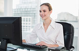 Smiling businesswoman sitting at desk