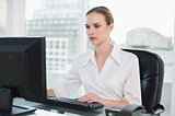 Serious businesswoman sitting at desk