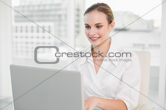 Happy businesswoman using laptop