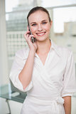 Smiling businesswoman making a call on her smartphone