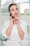 Thoughtful businesswoman making a call on her smartphone