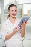 Happy businesswoman holding her tablet pc