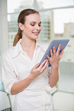 Smiling businesswoman holding her tablet pc
