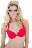 Pretty stern blonde model looking at camera in red bikini