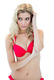 Slim blonde model in red bikini looking left