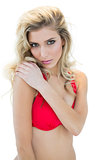 Mysterious attractive blonde model in red bikini looking at camera