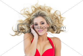 Attractive blonde model wearing red bikini touching her temple