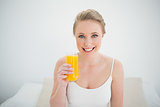 Natural cheerful blonde holding glass of orange juice