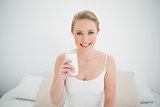Natural smiling blonde holding glass of milk