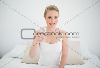 Natural smiling blonde holding glass of water