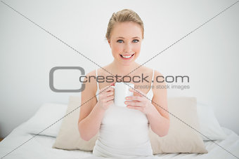 Natural smiling blonde holding a mug