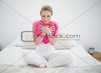 Natural content blonde holding heart pillow