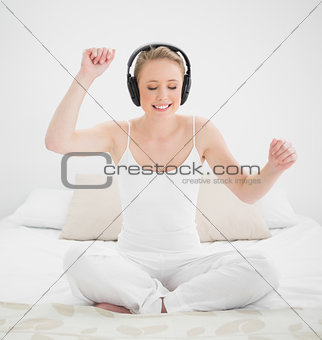 Natural happy blonde listening to music with closed eyes