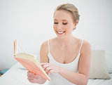 Natural smiling blonde reading a book