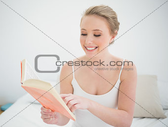 Natural smiling blonde reading a book