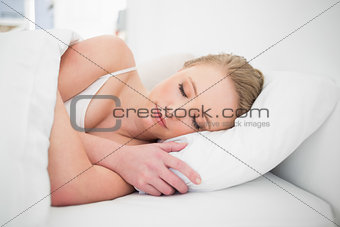 Natural peaceful blonde sleeping in bed