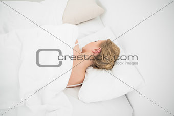 Natural beautiful blonde sleeping in bed